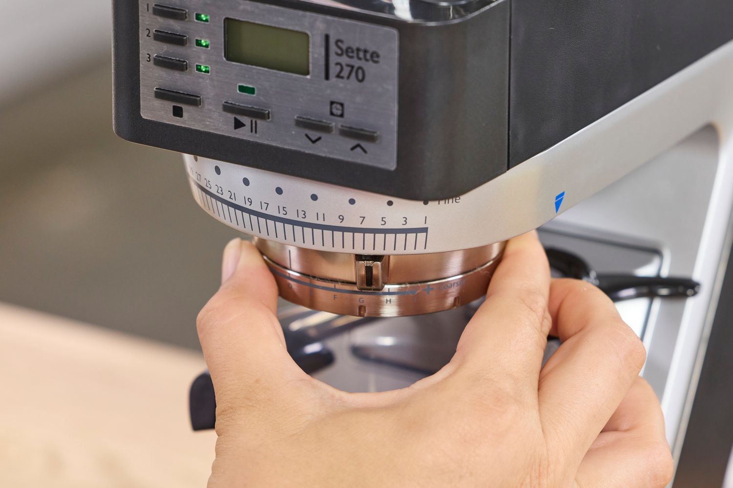 A person adjusts the grind setting on the Baratza Sette 270 Conical Burr Grinder