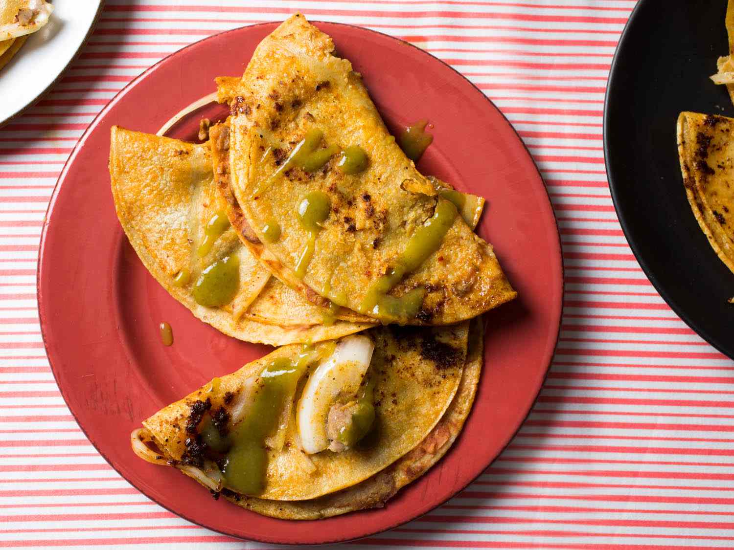 Overhead shot of 3 canasta tacos topped with salsa verde
