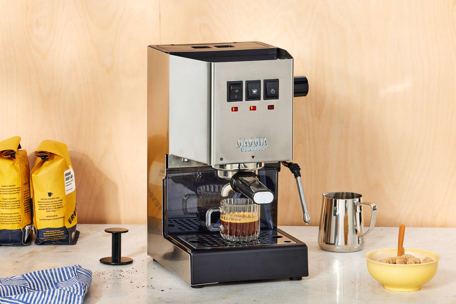 The Gaggia Classic Pro Espresso Machine brewing coffee into a glass cup on a marble counter top