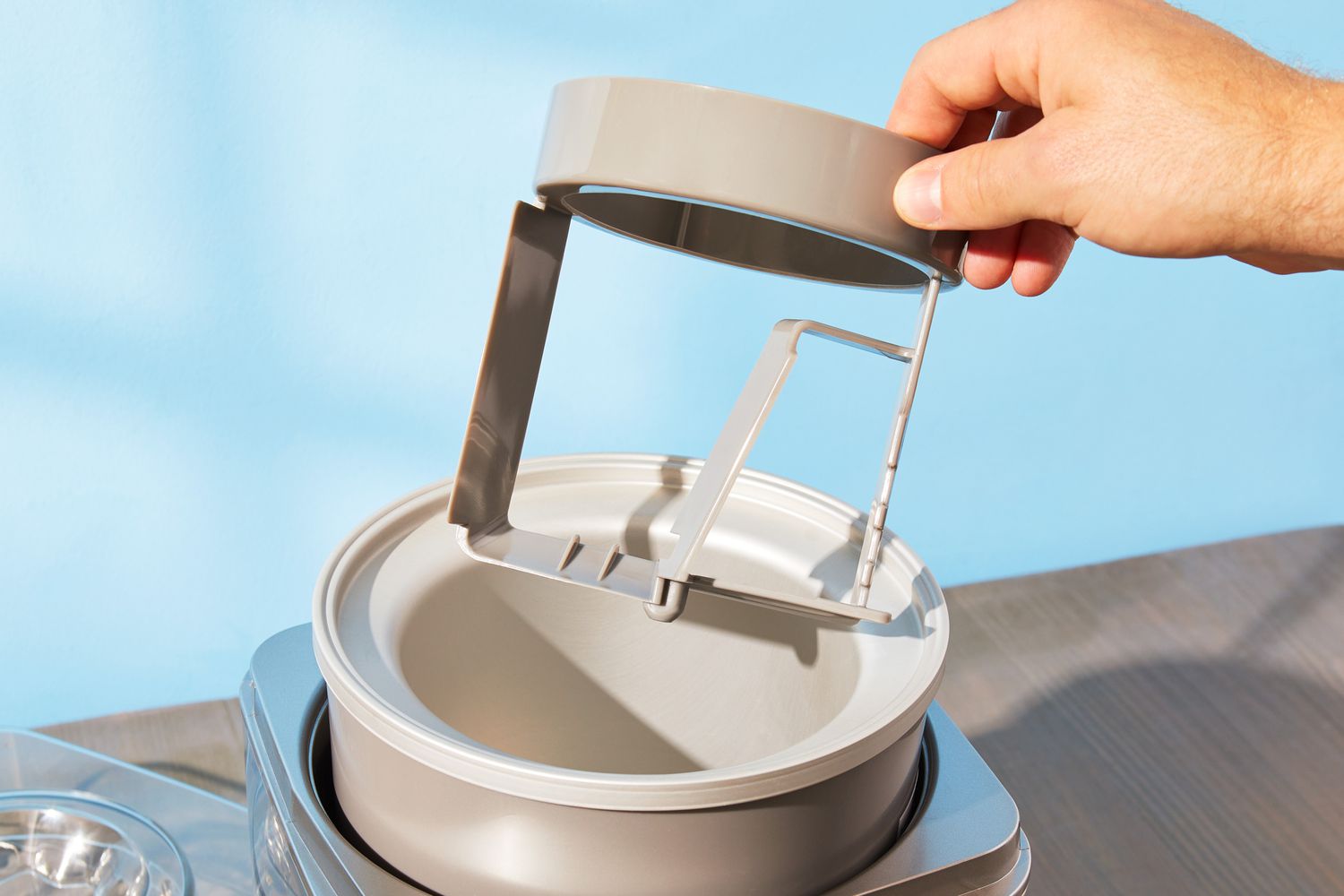 a hand removing the paddle from an ice cream maker