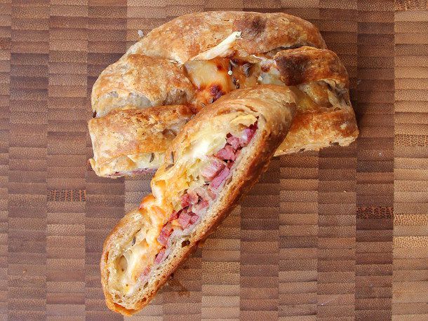 Overhead view of a halved reuben danish. One half has been propped up to show the filling.