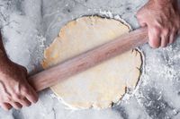 Person using a J.K. Adams Maple French Rolling Pin to flatten dough on a surface
