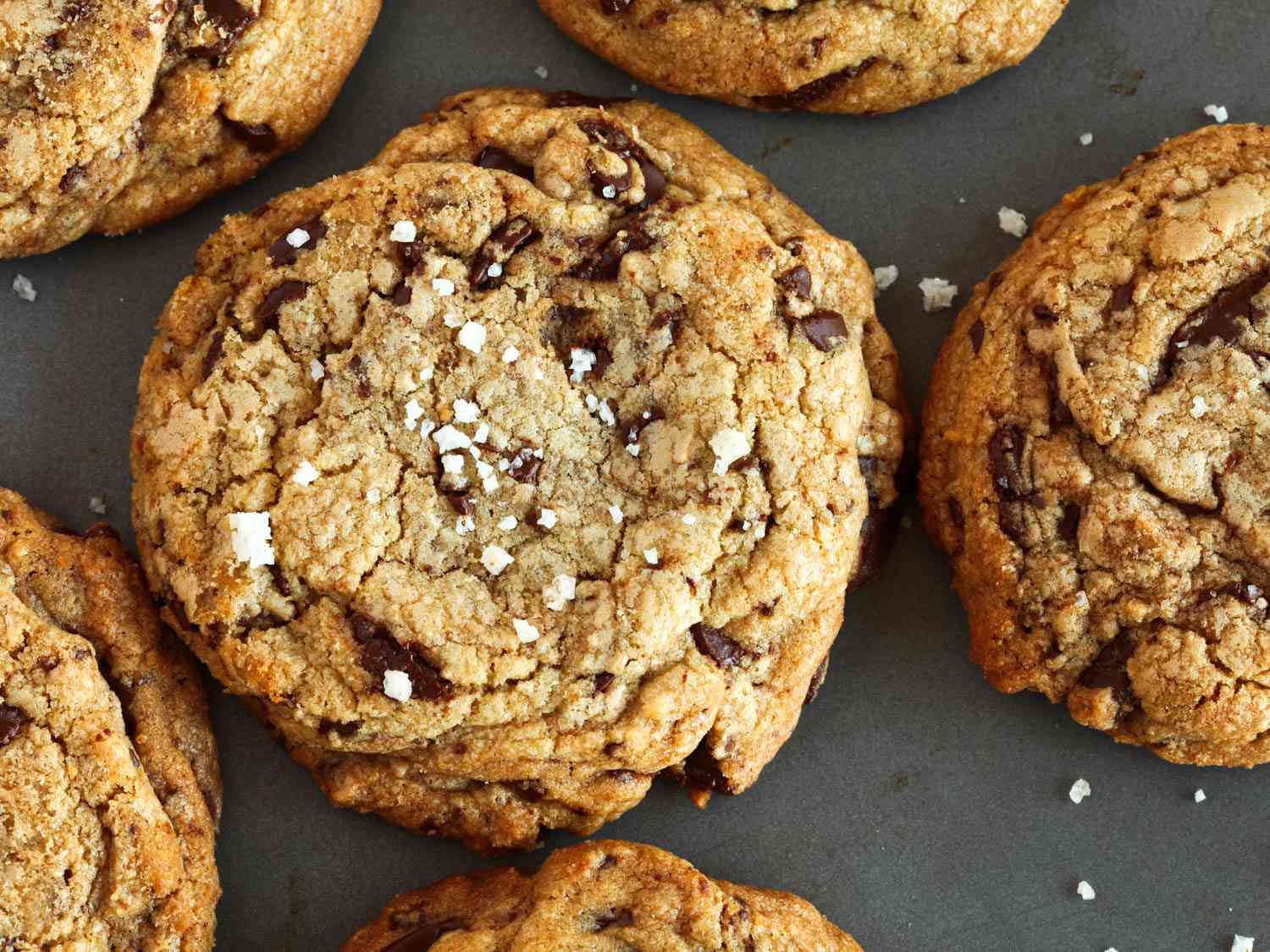 Close-up chocolate chip cookies showing craggy top and flakes of salt.