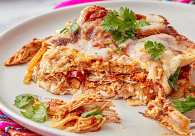 Mexican pastel azteca dish served on a plate garnished with fresh cilantro and melted cheese