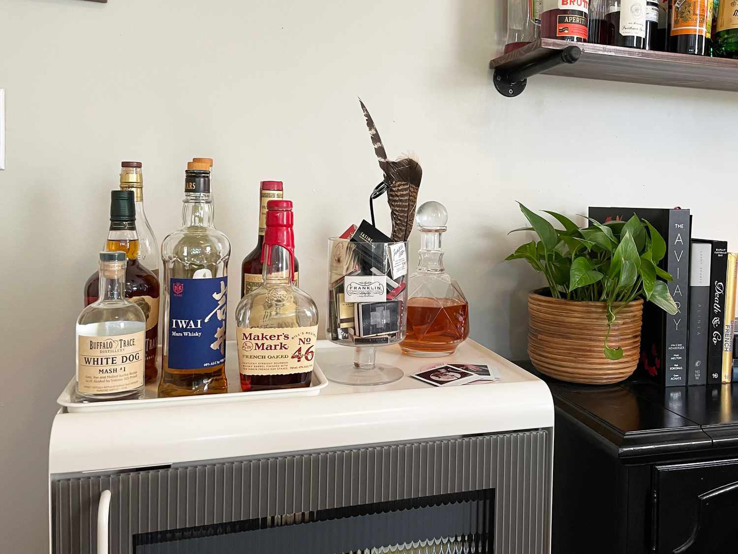 A collection of alcohol bottles on top of the Rocco Super Smart fridge.