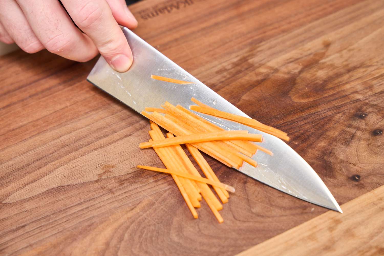 Finely sliced carrot on the Misono UX10 Chef’s Knife No. 712 blade