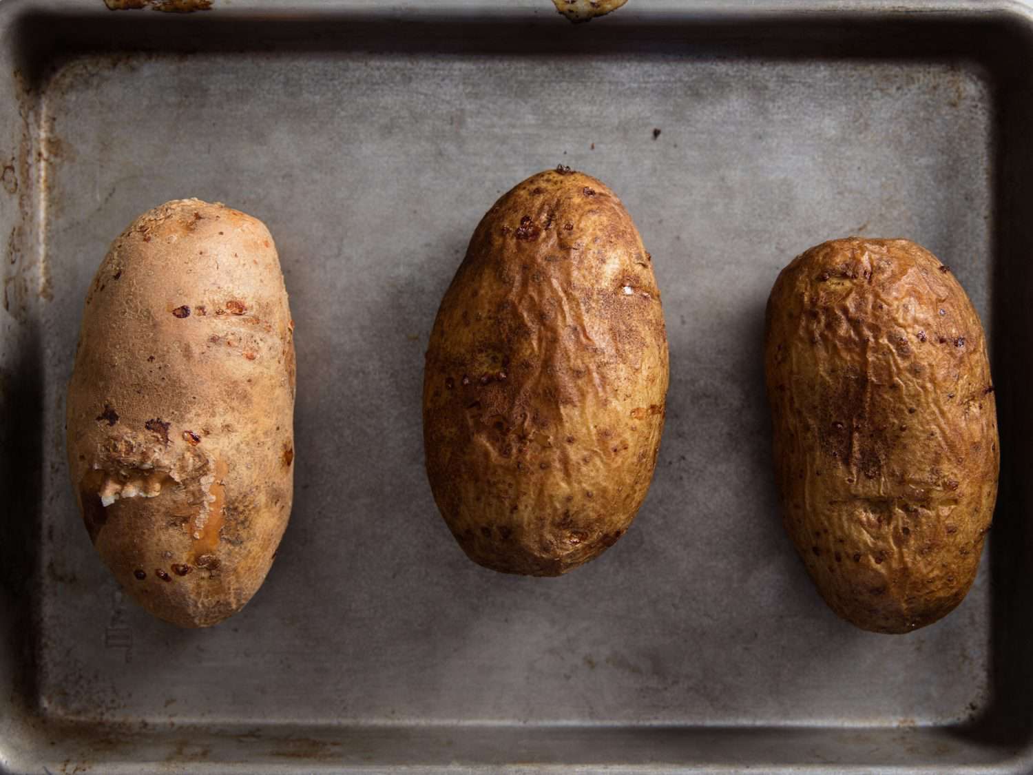 Overhead photo of baked potatoes on baking tray.