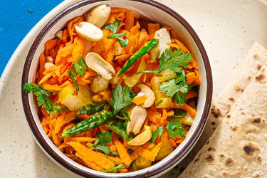Overhead view of Gajarachi Koshimbir, served in a bowl with flatbreads nearby.