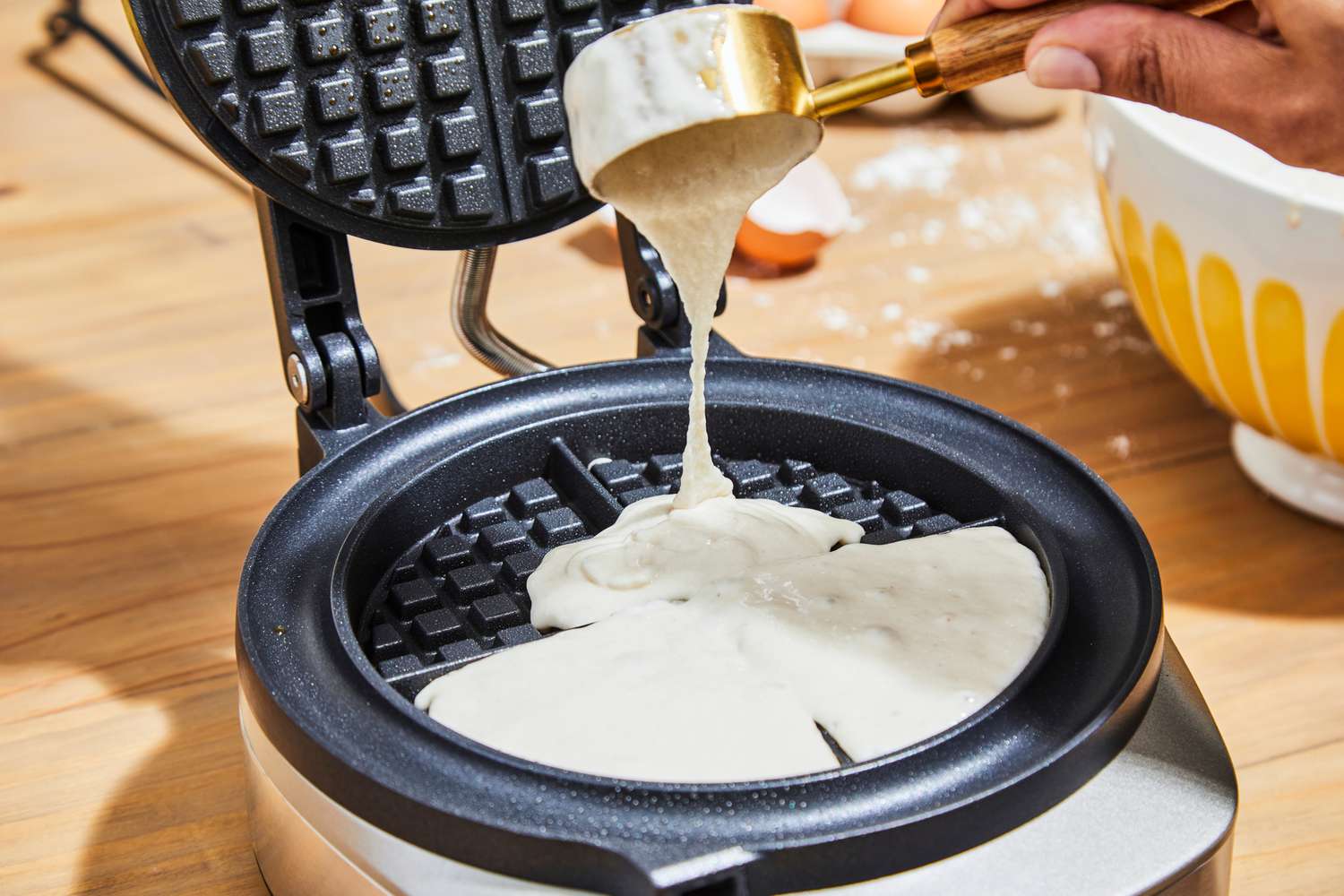 Person pouring batter into Breville No-Mess Waffle Maker