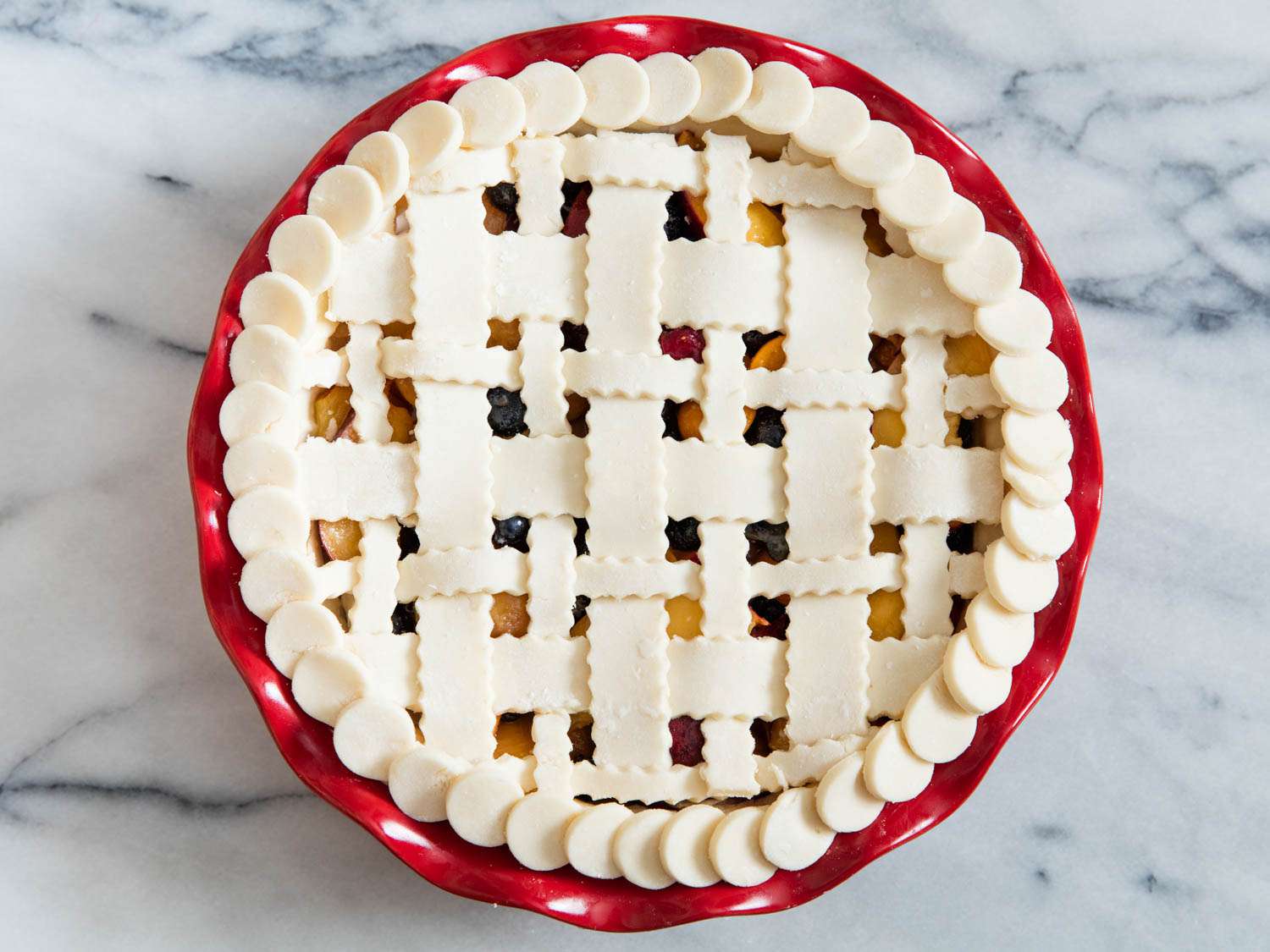 An unbaked lattice pie sitting on a marble countertop