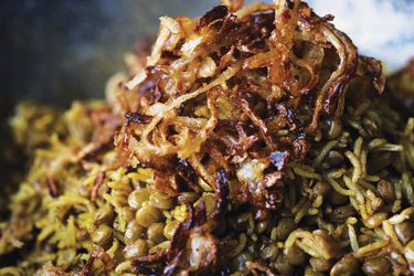 A pile of mejadra topped with freshly fried onions. 