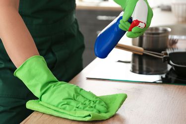 Person cleaning a kitchen counter