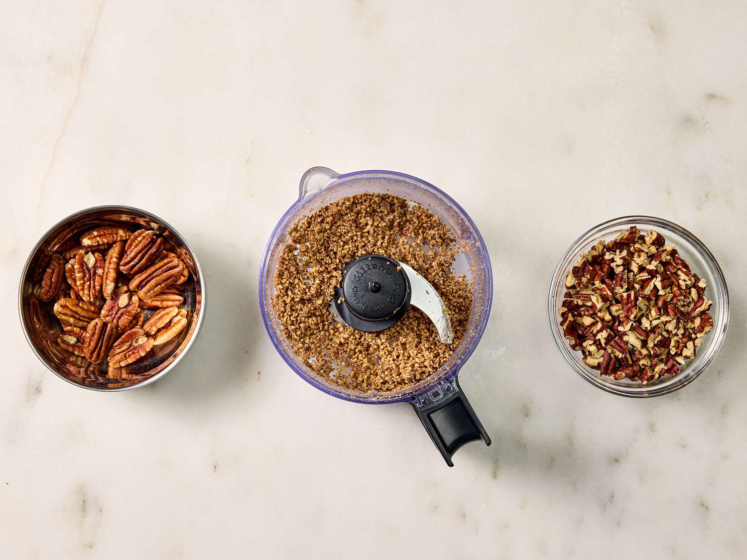 bowl of whole pecans, food processor with ground pecans, and small bowl of chopped pecans 