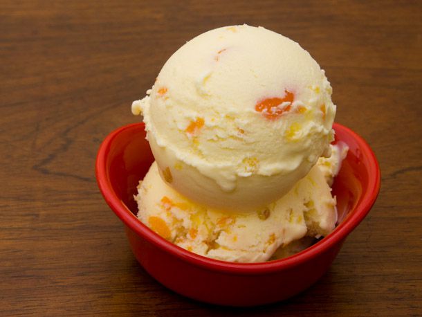 A small red bowl with scoops of homemade kumquat lemongrass ice cream.