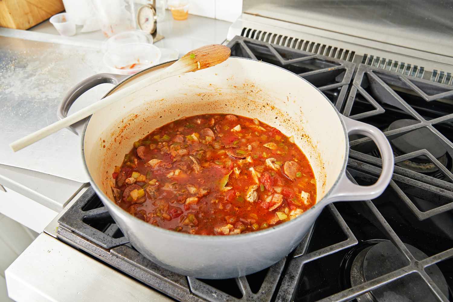 A grey dutch oven cooking food on a stovetop