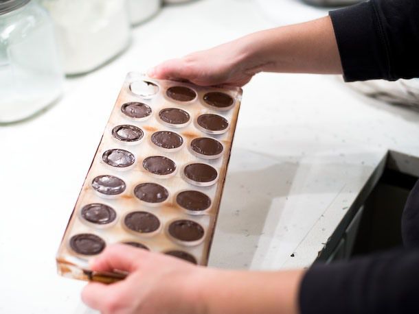 Flexing the bonbon mold to release the hardened chocolate.