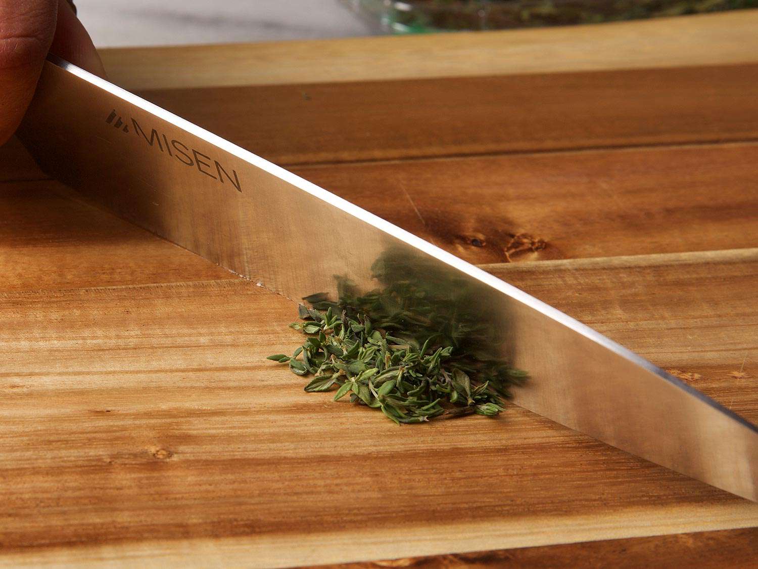 A knife scraping against a wooden cutting board