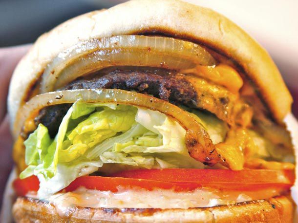 Closeup of the whole grilled onions adorning a burger from In-n-Out.