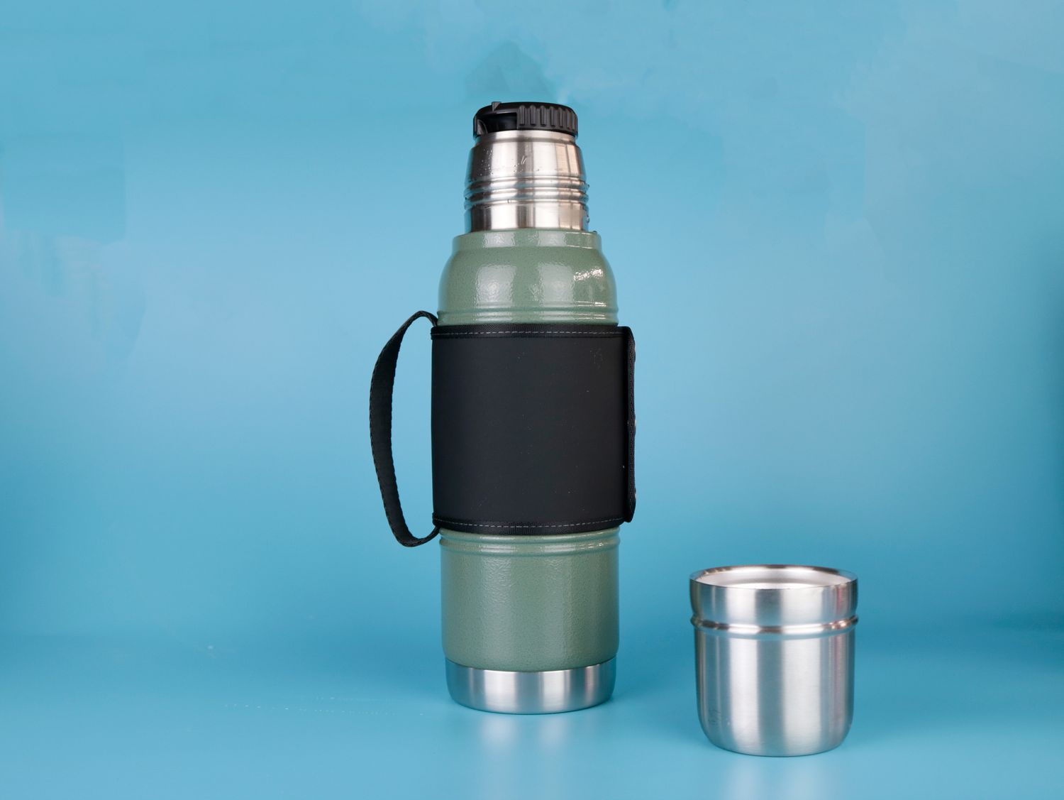 A thermos with its cup lid off against blue backdrop