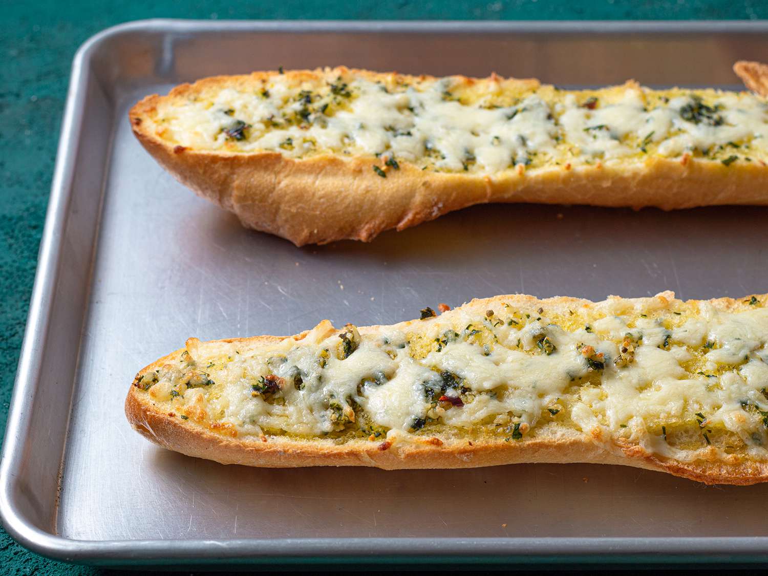 Cheese melted on the french bread spread with butter and herbs.