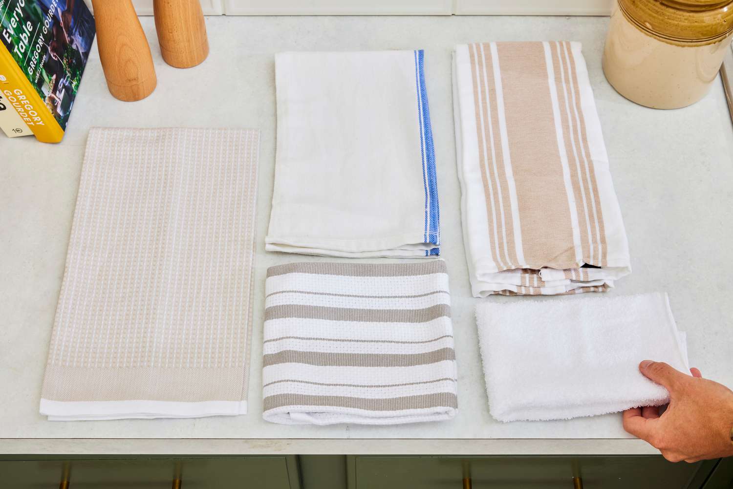 Several kitchen towels on a kitchen countertop.