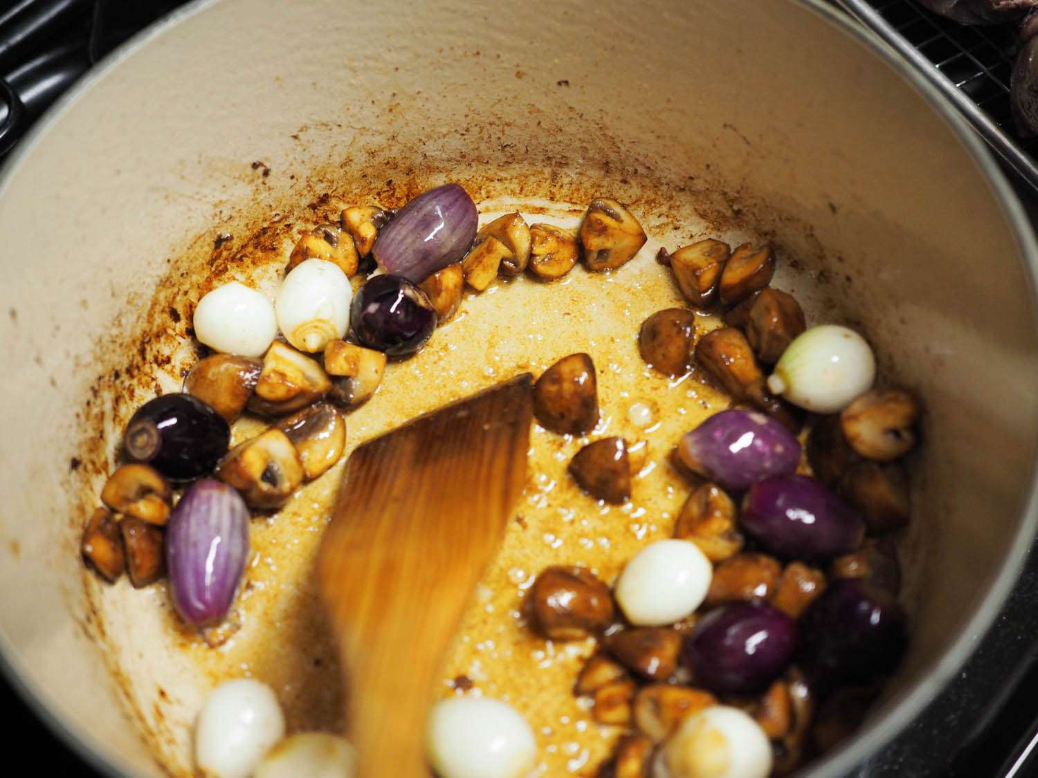 Pearl onions have been added to the pot to brown.