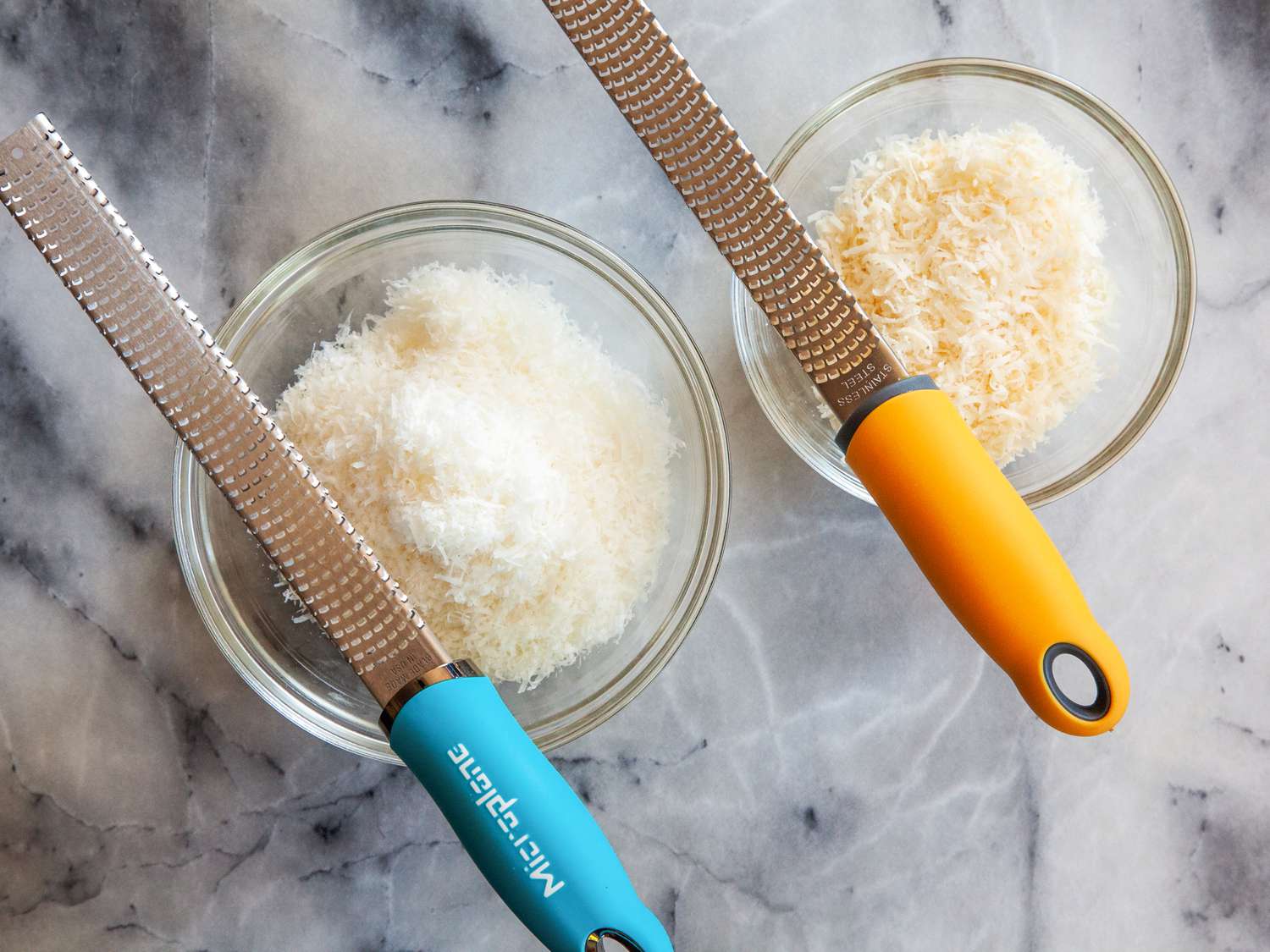 Two bowls of Parmesan cheese grated by two different rasp-style graters