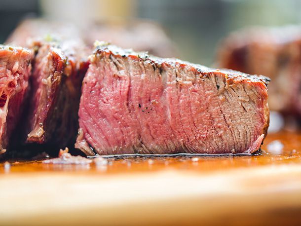 A close-up of the first reverse-seared porterhouse, cut open to show its doneness (medium-rare).
