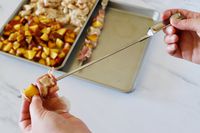 threading ingredients onto a stainless steel skewer