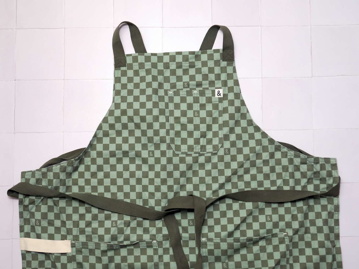 hexclad crossback apron on a white tile surface