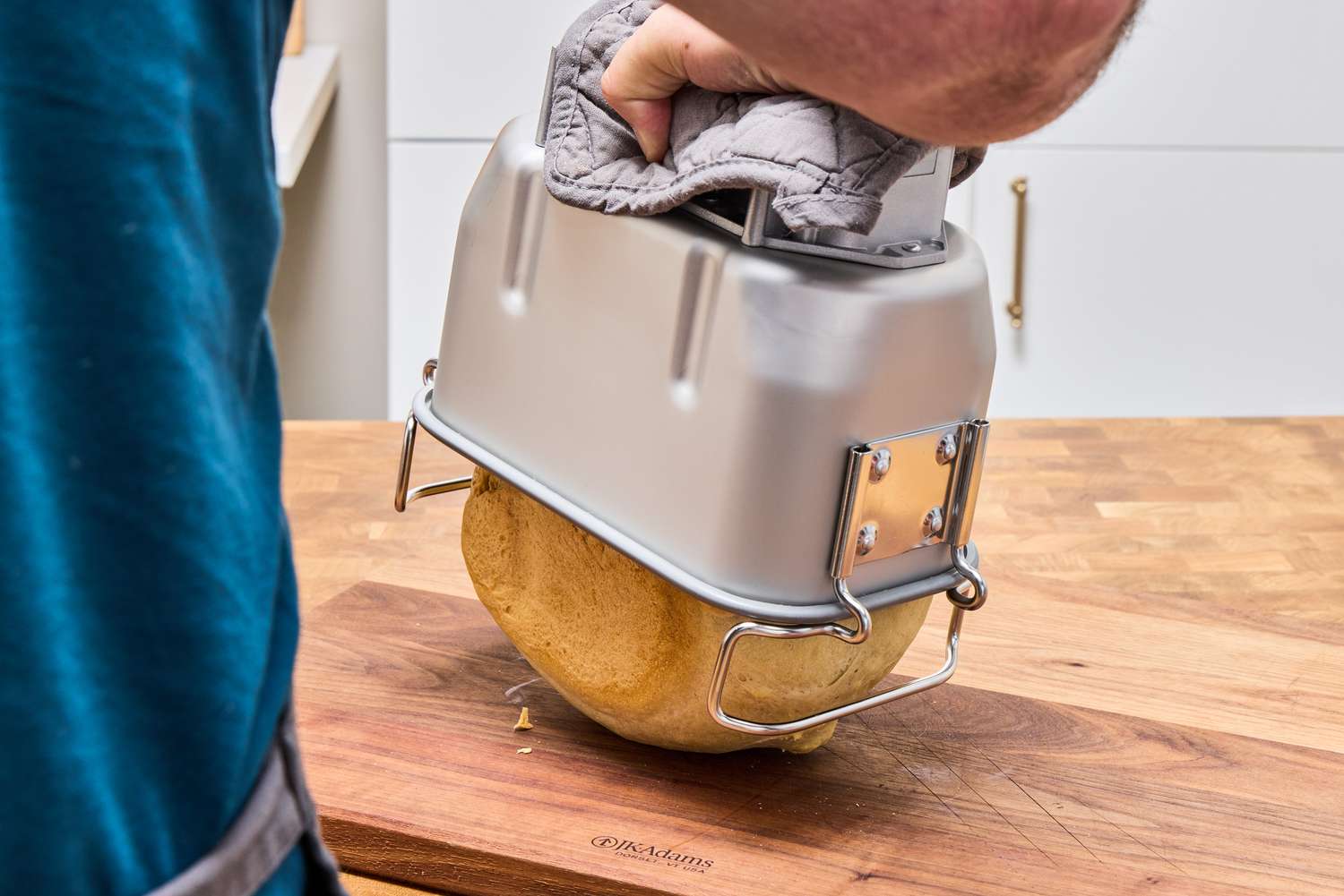 A person removes a fresh loaf of bread from the Zojirushi Home Bakery Virtuoso Plus Bread Maker