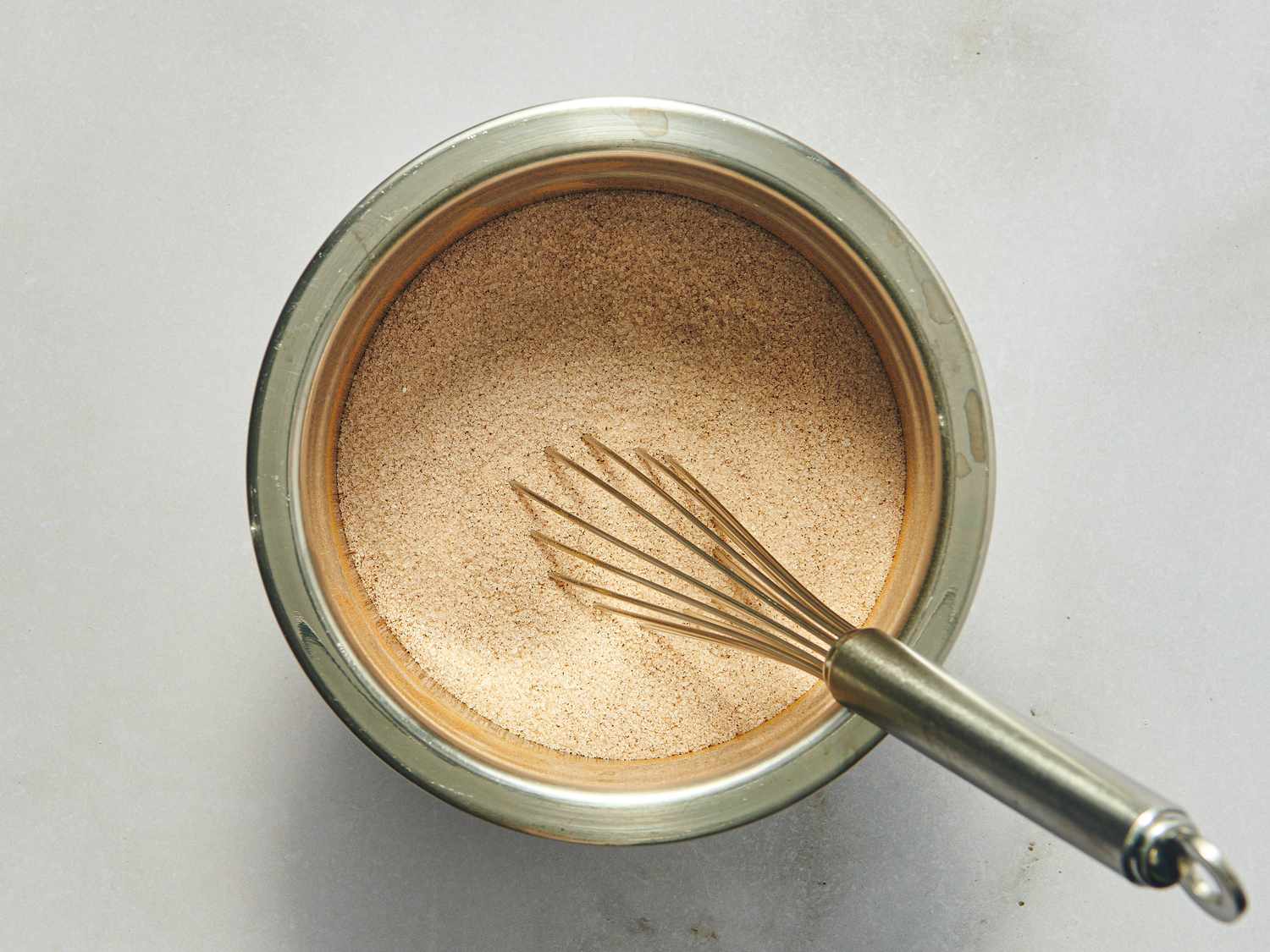 Bowl containing a dry mixture being whisked