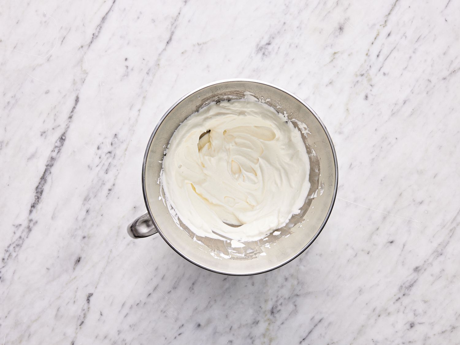 Overhead view of whipped cream in a stand mixer bowl
