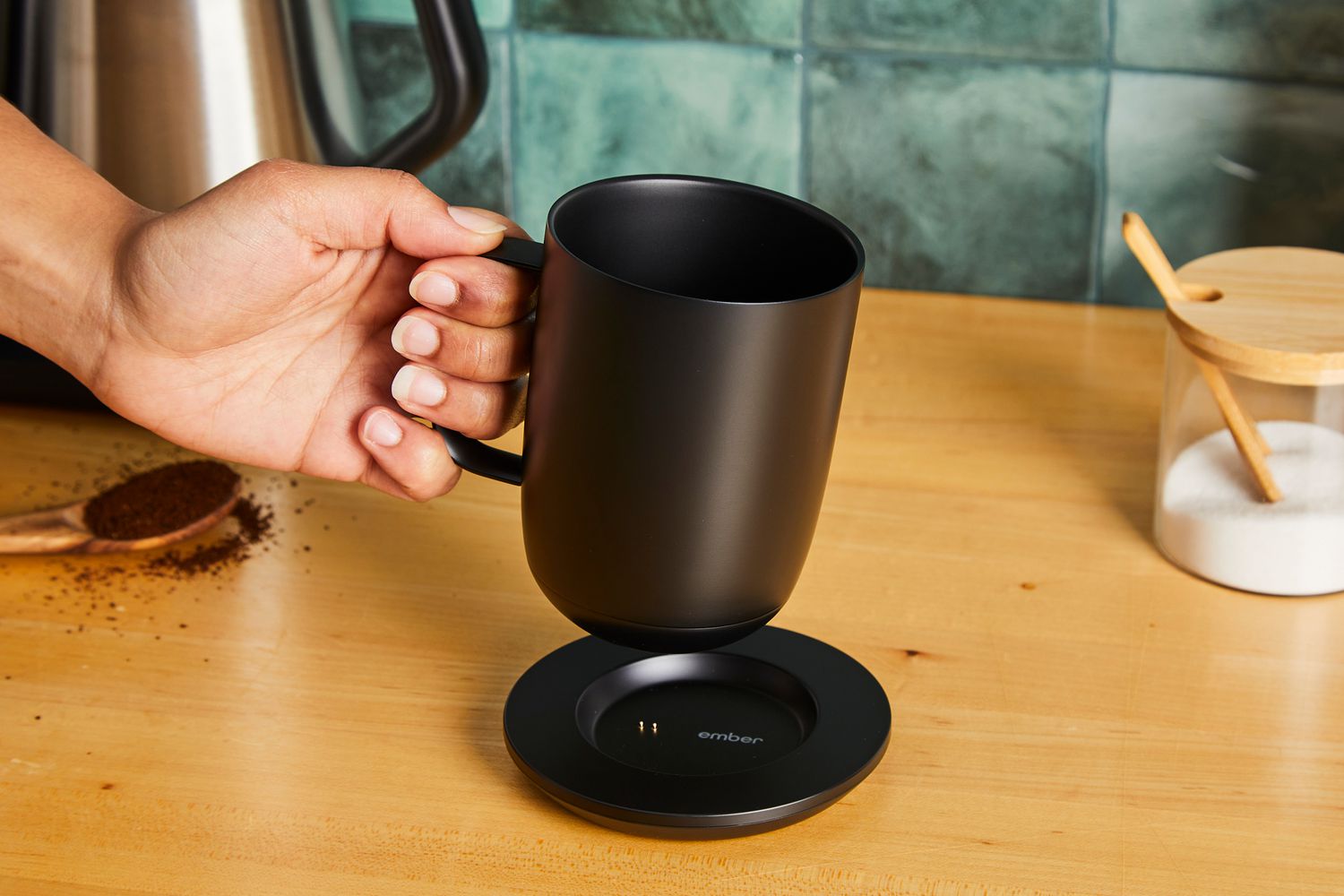 A person picking the Ember mug off of its charging platform.
