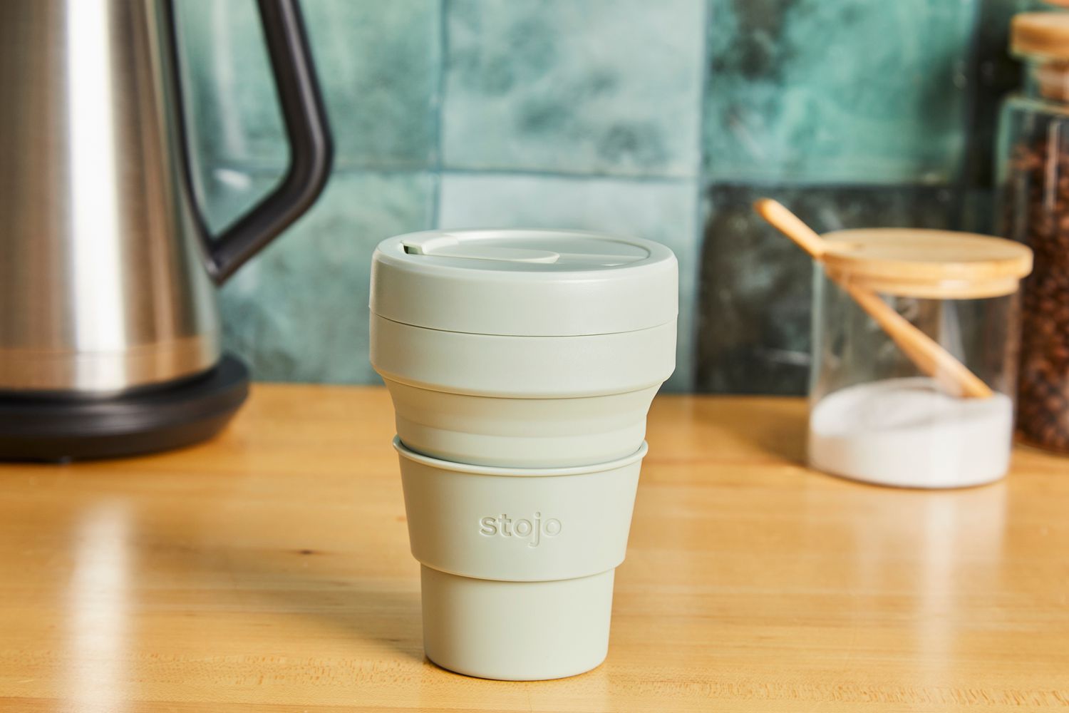 A Stojo travel cup on a kitchen countertop.