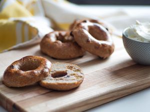 Sliced and toasted homemade cinnamon raisin bagels on a cutting board. 