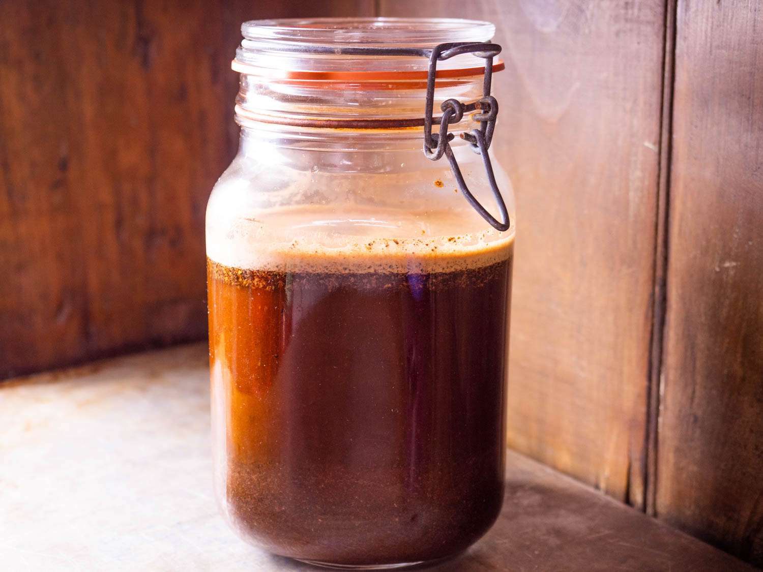 Coffee cold brewing in a glass jar.