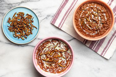 Overhead view of two bowls of Champorado and a side plate of candied anchovies