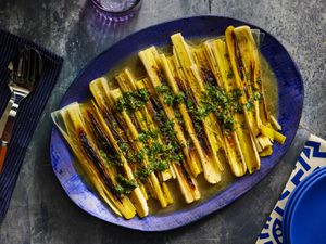 Overhead view of finished leeks plated on a blue platter
