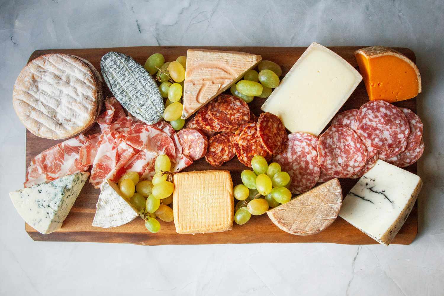 A charcuterie board with meats and cheeses on it.
