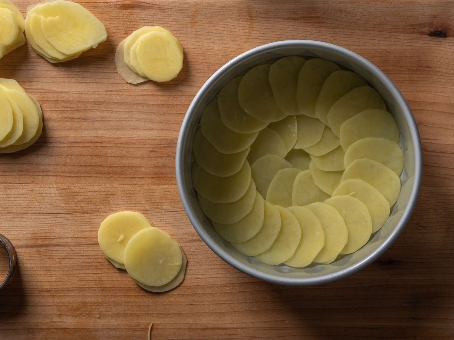 The first layer of pommes anna, built into an 8-inch aluminum cake pan.