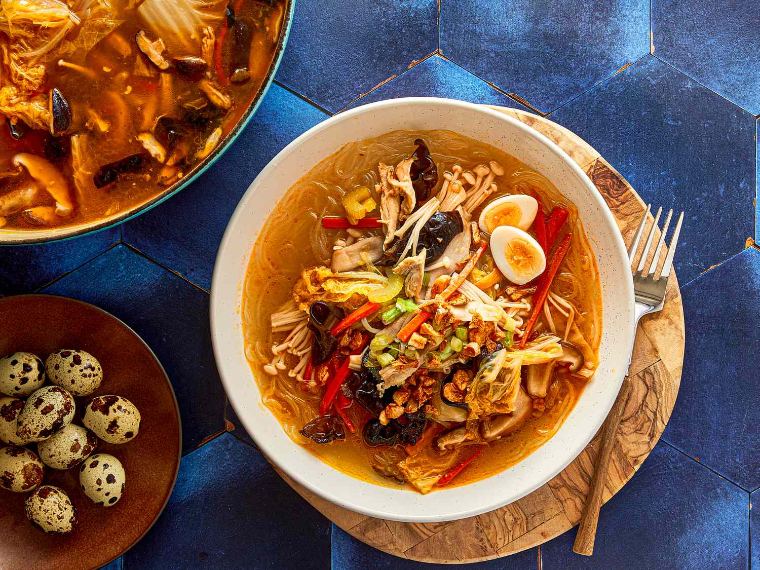 A bowl of chicken sotanghon soup served with quail eggs on the side