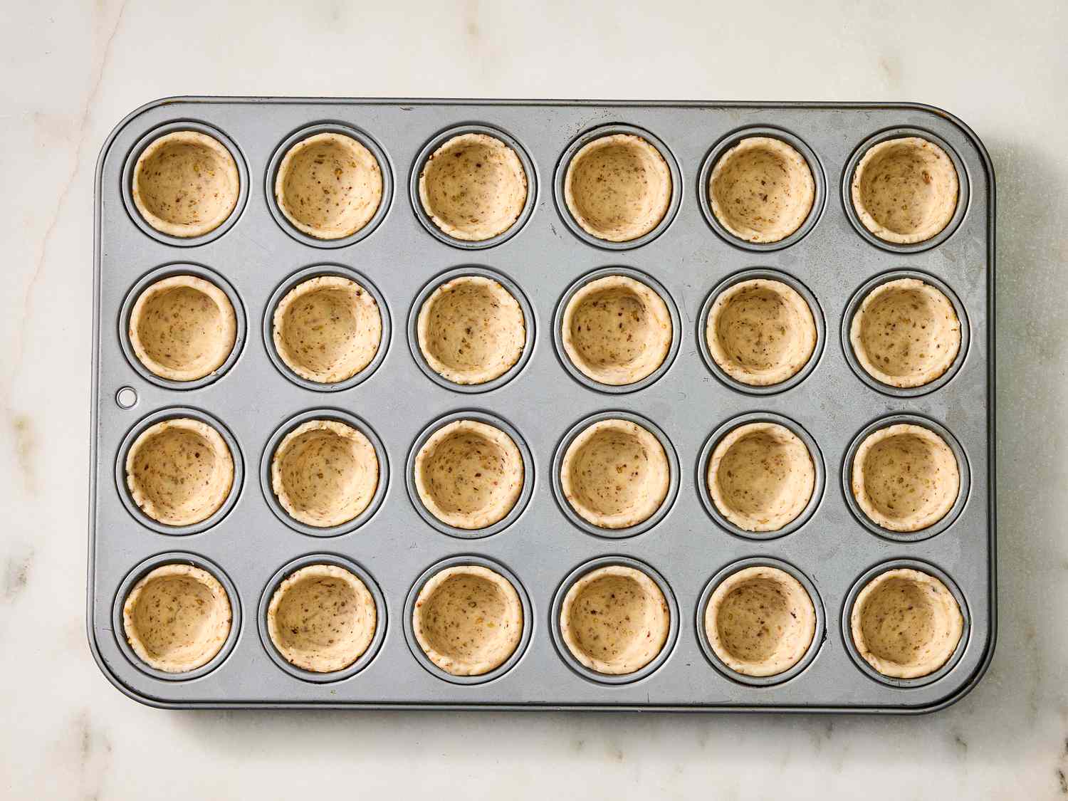 Dough pressed into mini muffin pan