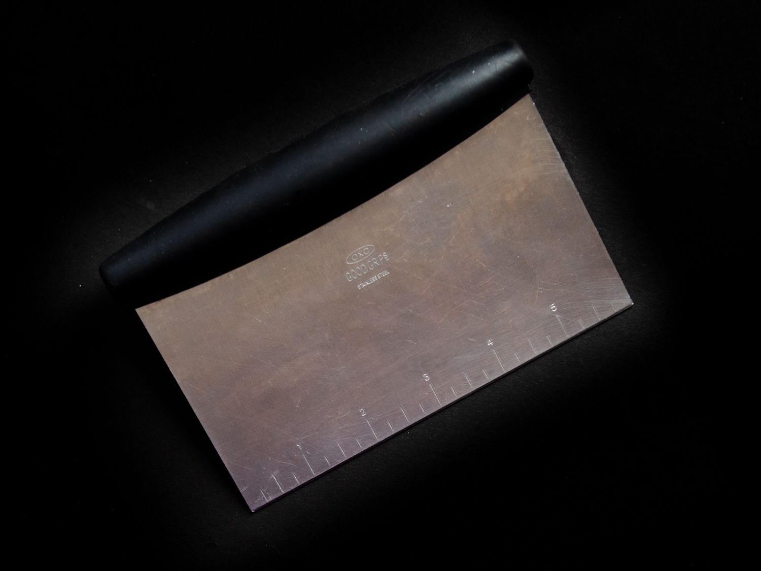 OXO Bench Scraper on a black background