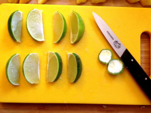 8 cut lime wedges on a cutting board.