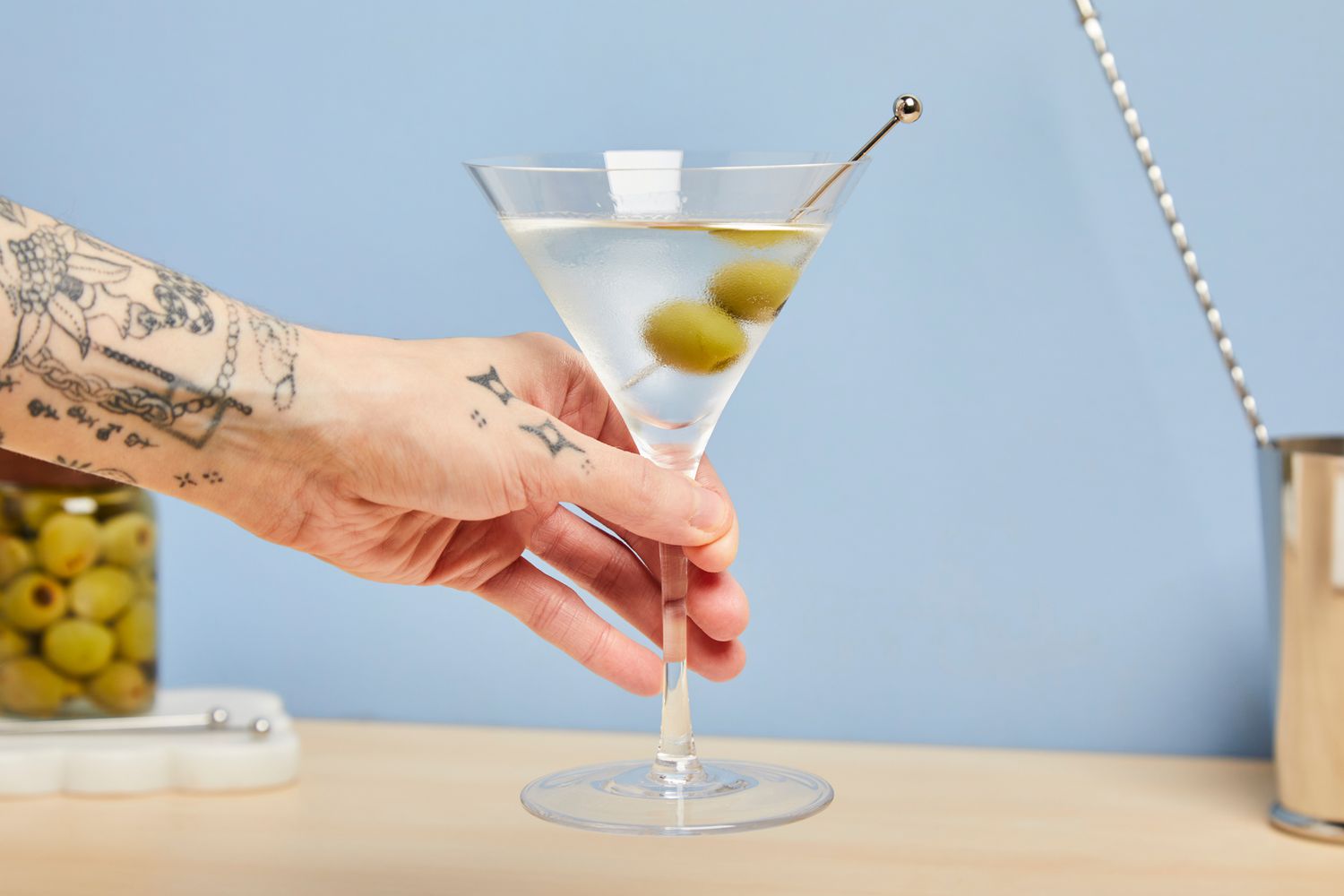a person holding a martini in a v-shaped glass