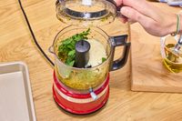 a person puts a lid on a food processor