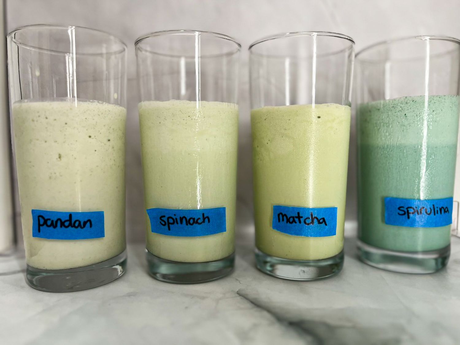 Labeled milkshakes in glasses with pandan, spinach, matcha, and spirulina