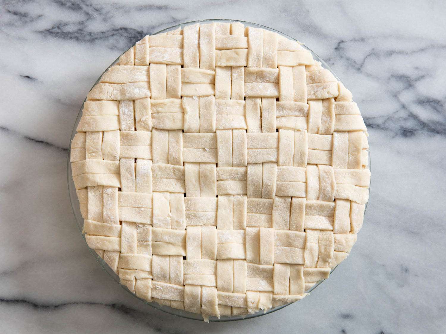 Unbaked summer fruit pie with the basketweave top crust complete.