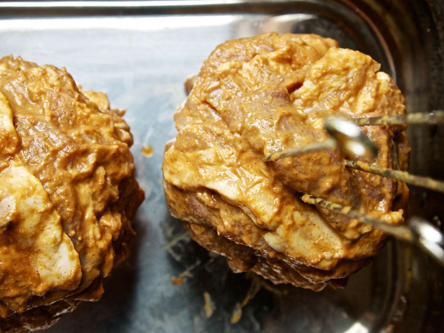 Closeup of the skewered meat affixed to the onion and erected in a roasting pan.